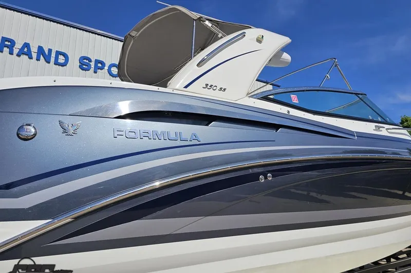 Slide: The Image of 2015 Formula 350 Sun Sport boat with sleek design and blue accents under clear sky. - 11