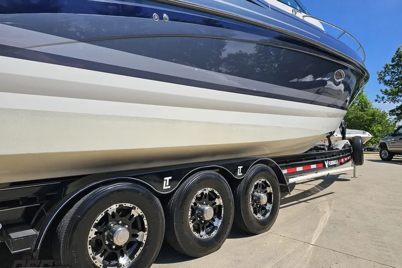 Slide: The Image of 2015 Formula 350 Sun Sport boat on a triple-axle trailer, parked outdoors. - 12