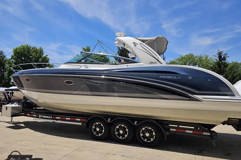 Slide: The Image of 2015 Formula 350 Sun Sport boat on trailer under clear blue sky. - 23