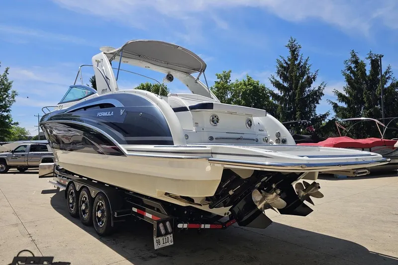 Slide: The Image of 2015 Formula 350 Sun Sport boat on trailer, parked outdoors under clear sky. - 27
