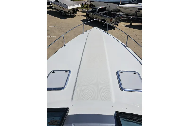 Slide: The Image of 2015 Formula 350 Sun Sport boat deck with hatches, parked near trucks and trailers. - 76