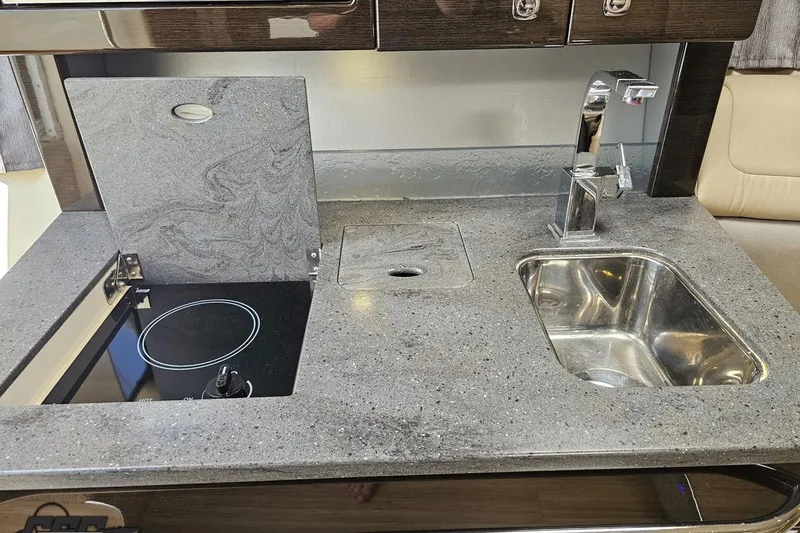 Slide: The Image of Modern kitchen area in a 2015 Formula 350 Sun Sport boat, featuring a sleek sink and stovetop. - 92