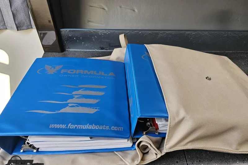 Slide: The Image of Blue Formula 350 Sun Sport 2015 owner manuals in a beige bag on a dark surface. - 94