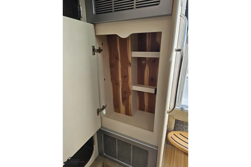 Slide: The Image of Open cabinet with wooden shelves inside a 2015 Formula 350 Sun Sport boat. - 98