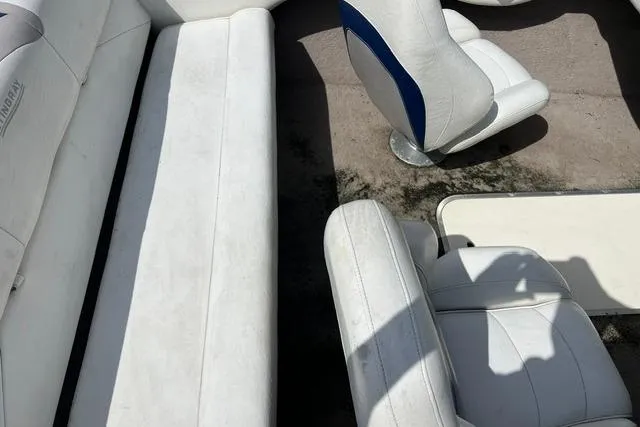 Slide: The Image of Interior of a 2005 Stingray 180 RX boat with white seating and blue accents. - 4