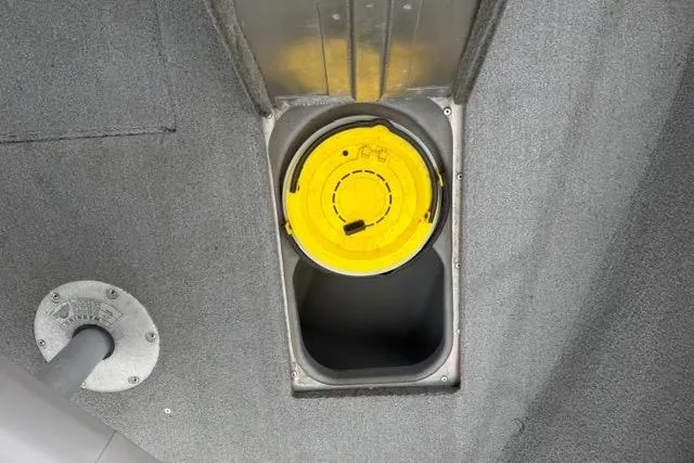 Slide: The Image of 2011 Tracker Pro Guide V-175 SC boat compartment with yellow lid on gray carpet. - 18