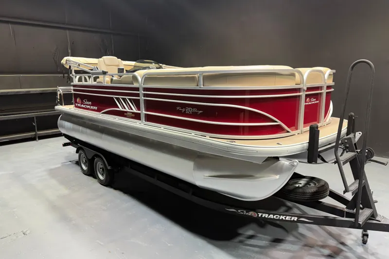 The Image of 2023 Sun Tracker Party Barge 20 DLX pontoon boat on trailer in showroom. - 1
