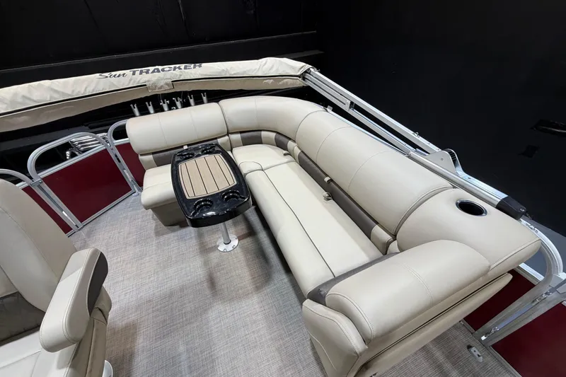Slide: The Image of 2023 Sun Tracker Party Barge 20 DLX interior with beige seating and central table. - 10