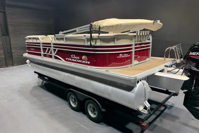 Slide: The Image of 2023 Sun Tracker Party Barge 20 DLX pontoon boat on trailer in a garage. - 3