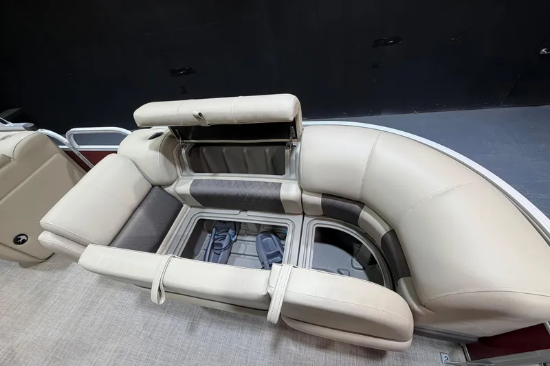 Slide: The Image of 2023 Sun Tracker Party Barge 20 DLX interior seating with storage compartments open. - 7