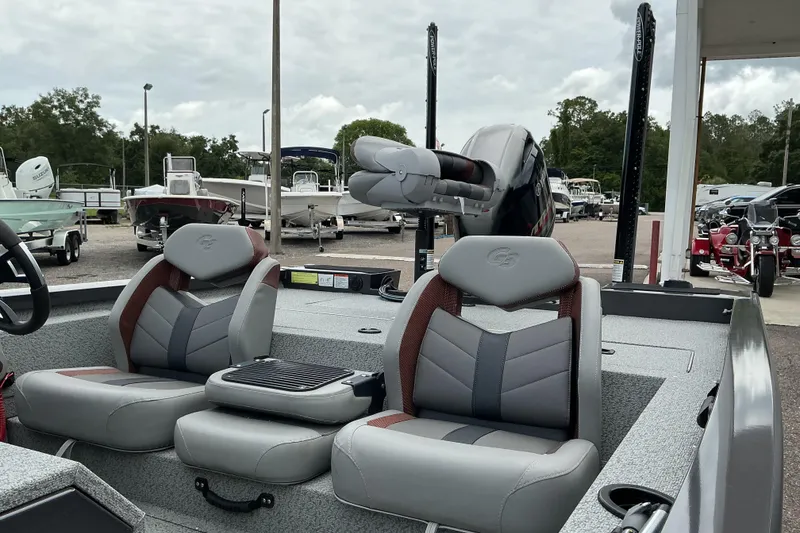 Slide: The Image of 2023 G3 Sportsman 1710 boat interior with dual seats and motor, displayed at a dealership. - 7