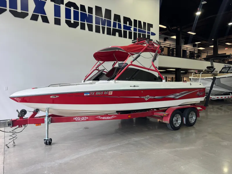 Slide: The Image of Red 2001 Tigé 21 V boat on trailer in showroom. - 3