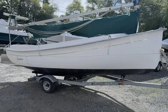 Slide: The Image of 2019 Com-Pac Picnic Cat sailboat on trailer, parked outdoors. - 1