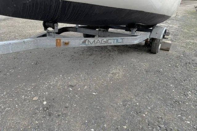 Slide: The Image of Trailer for 2019 Com-Pac Picnic Cat sailboat on gravel surface. - 14