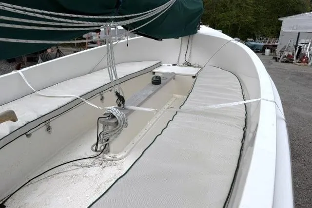 Slide: The Image of 2019 Com-Pac Picnic Cat sailboat with green canopy, docked outdoors. - 5