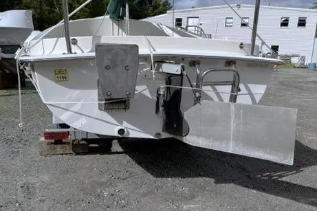 Slide: The Image of 2019 Com-Pac Picnic Cat sailboat on trailer, rear view, in outdoor setting. - 8