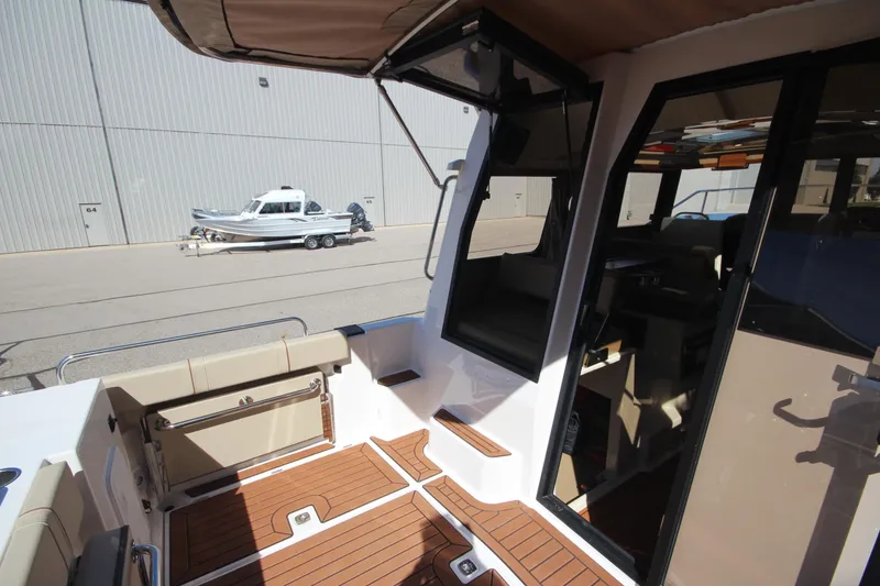 Slide: The Image of 2025 Ranger Tugs R-25 Luxury Edition boat interior with wood flooring and seating. - 13