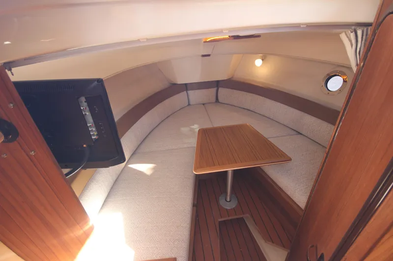 Slide: The Image of Interior of 2025 Ranger Tugs R-25 Luxury Edition, featuring cozy seating and wooden table. - 30