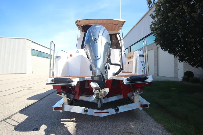 Slide: The Image of 2025 Ranger Tugs R-25 Luxury Edition boat with outboard motor, parked outdoors. - 6