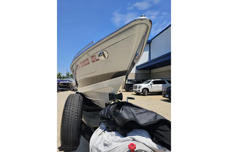 Slide: The Image of 2012 Formula 353 FASTech boat on trailer, parked outside a building under clear blue sky. - 15