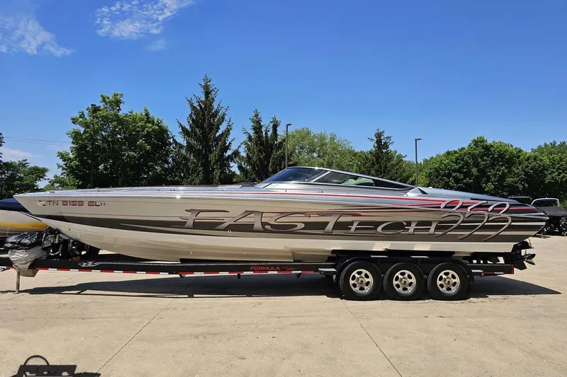 Slide: The Image of 2012 Formula 353 FASTech boat on trailer, parked outdoors under clear blue sky. - 19