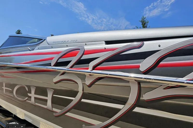 Slide: The Image of 2012 Formula 353 FASTech boat with sleek graphics and metallic finish under a clear sky. - 23