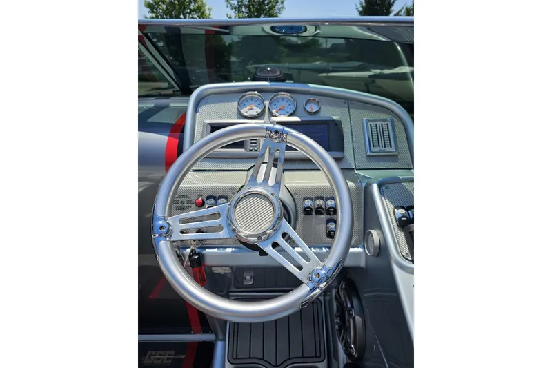 Slide: The Image of Steering wheel and dashboard of 2012 Formula 353 FASTech boat, featuring gauges and controls. - 63