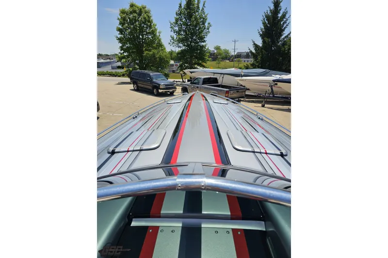 Slide: The Image of 2012 Formula 353 FASTech boat with sleek design and vibrant stripes in a parking area. - 74