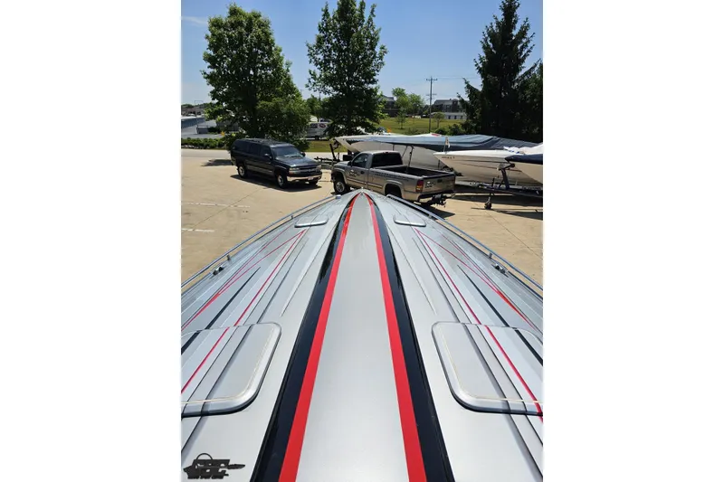 Slide: The Image of 2012 Formula 353 FASTech boat with sleek design, parked near vehicles and trees. - 75