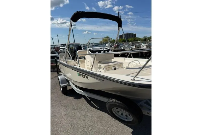 Slide: The Image of 2021 Boston Whaler 170 Montauk boat on trailer, sunny day, marina background. - 1