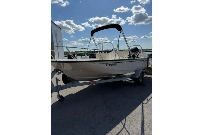 Slide: The Image of 2021 Boston Whaler 170 Montauk boat on trailer under a sunny sky. - 16