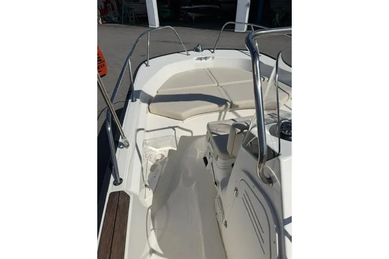 Slide: The Image of 2021 Boston Whaler 170 Montauk boat interior with cushioned seating and stainless steel railings. - 20