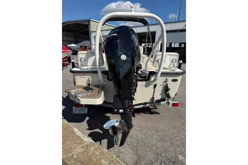Slide: The Image of 2021 Boston Whaler 170 Montauk boat with outboard motor, parked outdoors. - 9