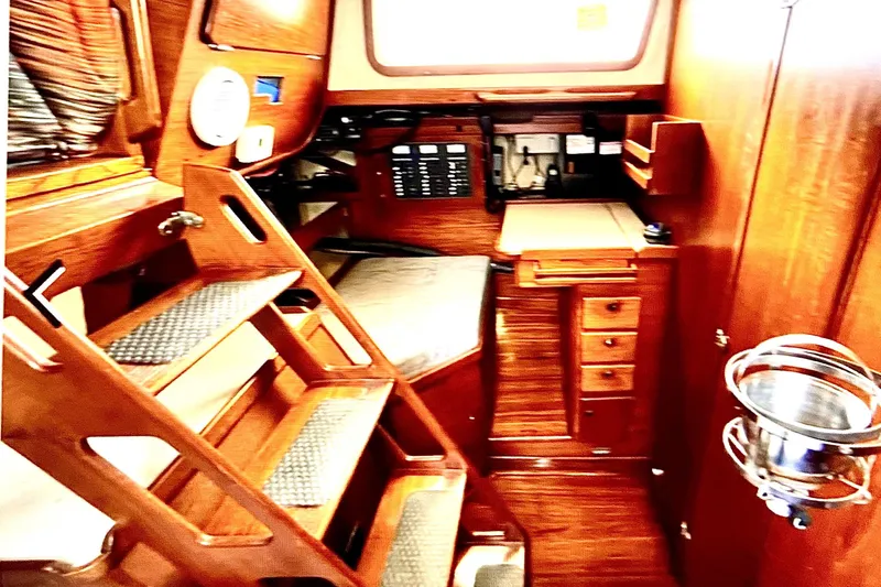 Slide: The Image of Interior of a 1986 Sabre 38 sailboat featuring wooden cabinetry and a compact navigation area. - 14