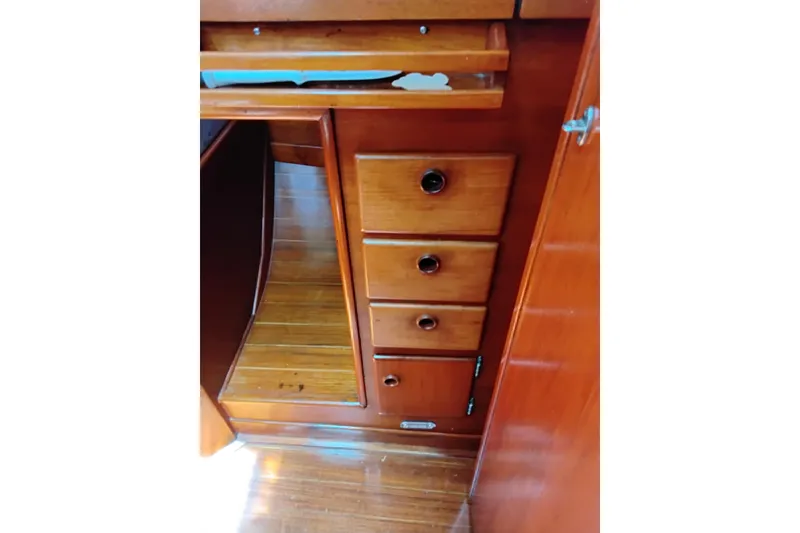 Slide: The Image of Wooden interior cabinetry of a 1986 Sabre 38 sailboat, featuring drawers and polished finish. - 17