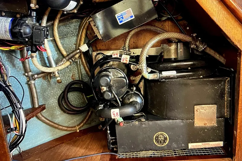 Slide: The Image of Engine compartment of a 1986 Sabre 38 sailboat, showing mechanical components and wiring. - 21