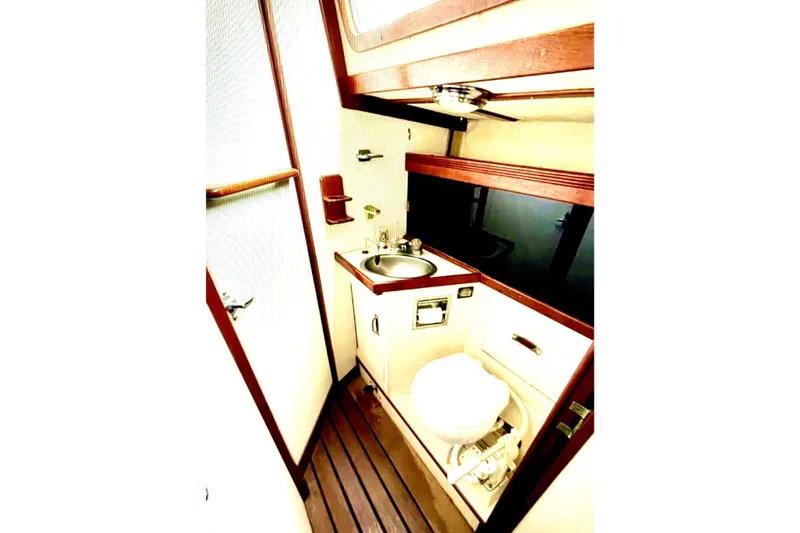 Slide: The Image of 1986 Sabre 38 yacht bathroom with sink, toilet, and wooden accents. - 24