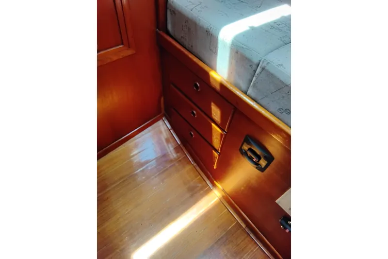 Slide: The Image of Interior of 1986 Sabre 38 sailboat showing wooden cabinetry and bed corner. - 26