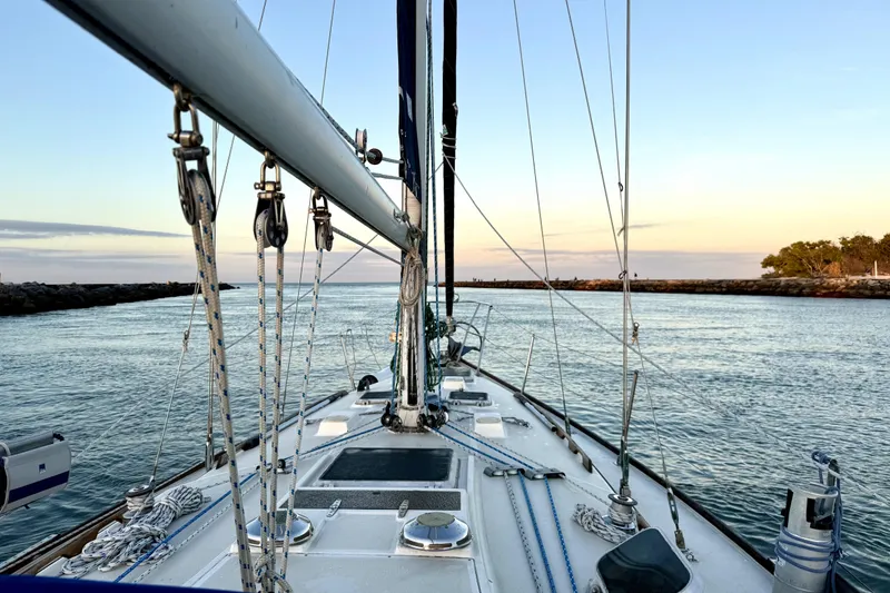 Slide: The Image of Sailing on a 1986 Sabre 38 yacht at sunset, entering a calm harbor. - 3