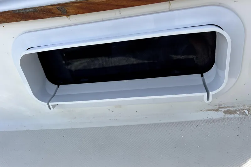 Slide: The Image of Vent window on a 1986 Sabre 38 boat, featuring a white frame and mesh screen. - 35