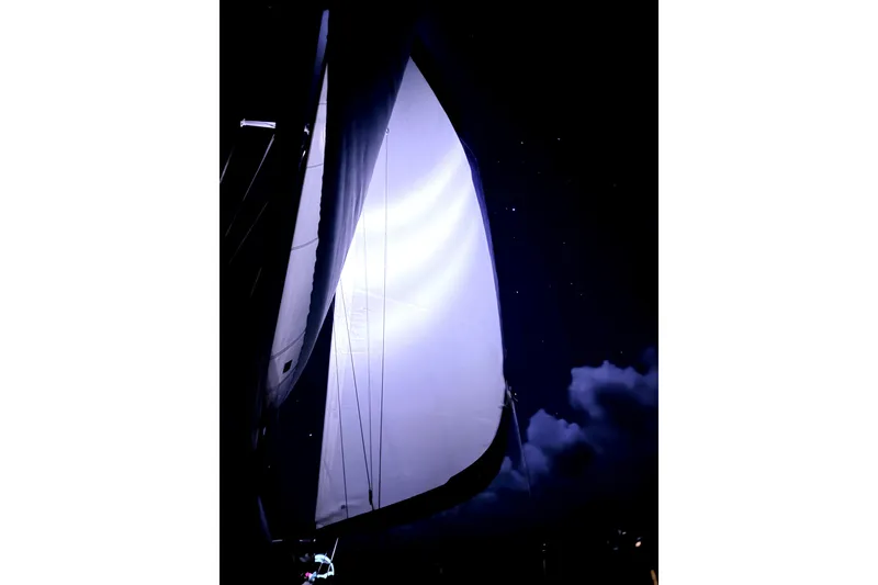 Slide: The Image of Sailboat Sabre 38 (1986) with illuminated sail against a starry night sky. - 37