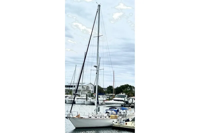 Slide: The Image of 1986 Sabre 38 sailboat docked in a marina, surrounded by other boats. - 38