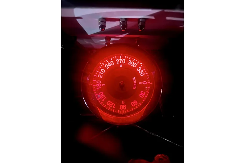 Slide: The Image of Red-lit compass on a 1986 Sabre 38 sailboat, displaying navigational directions. - 39