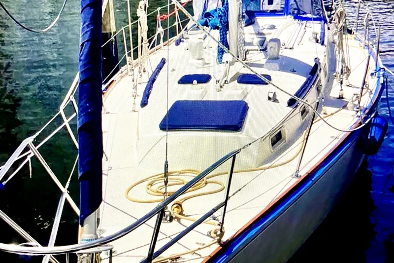 Slide: The Image of 1986 Sabre 38 sailboat docked, featuring a clean deck and blue accents. - 5