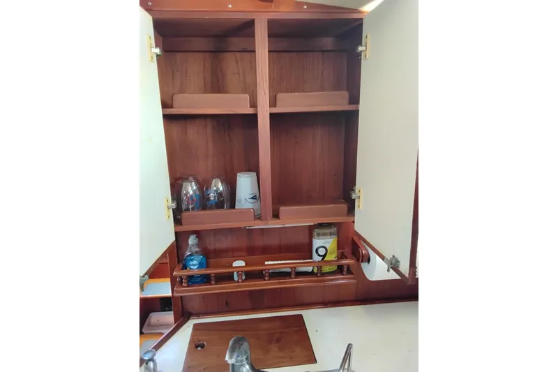 Slide: The Image of 1986 Sabre 38 yacht interior cabinet with shelves and stored items. - 9