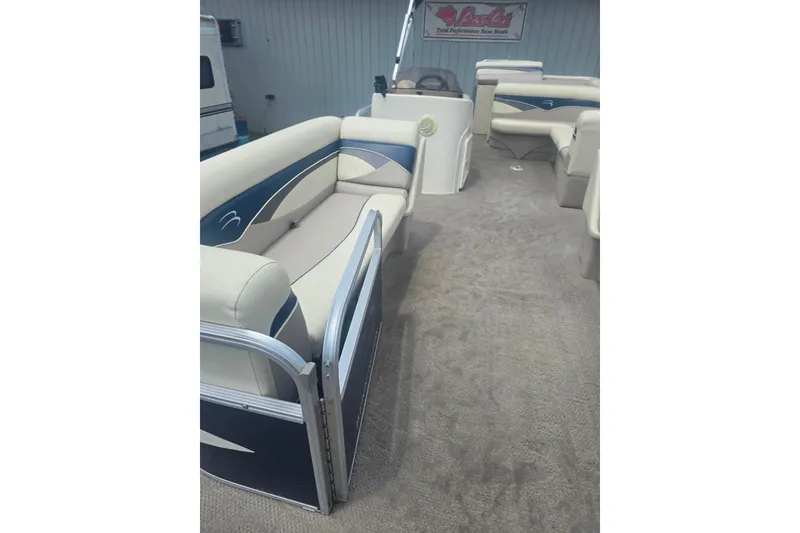 Slide: The Image of 2009 Bennington 2275SL pontoon boat interior with plush seating and carpeted flooring. - 7