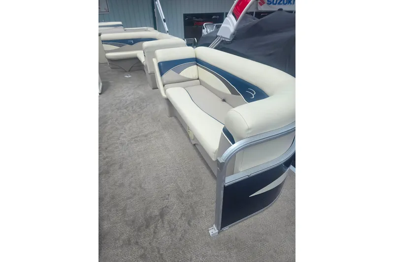 Slide: The Image of 2009 Bennington 2275SL pontoon boat with beige and blue seating on carpeted deck. - 8