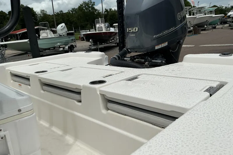 Slide: The Image of 2022 NauticStar 215 XTS Shallow Bay boat with Yamaha 150 engine, parked outdoors. - 11