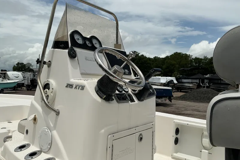 Slide: The Image of 2022 NauticStar 215 XTS Shallow Bay boat console with steering wheel and gauges. - 9