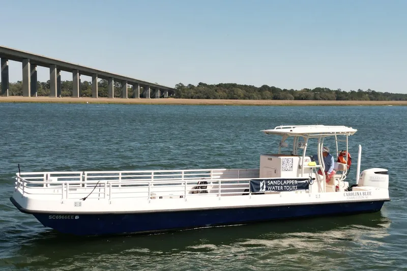 The Image of Custom Henriksen Design Group boat, 2023 model, offering Sandlapper Water Tours on a scenic river. - 1